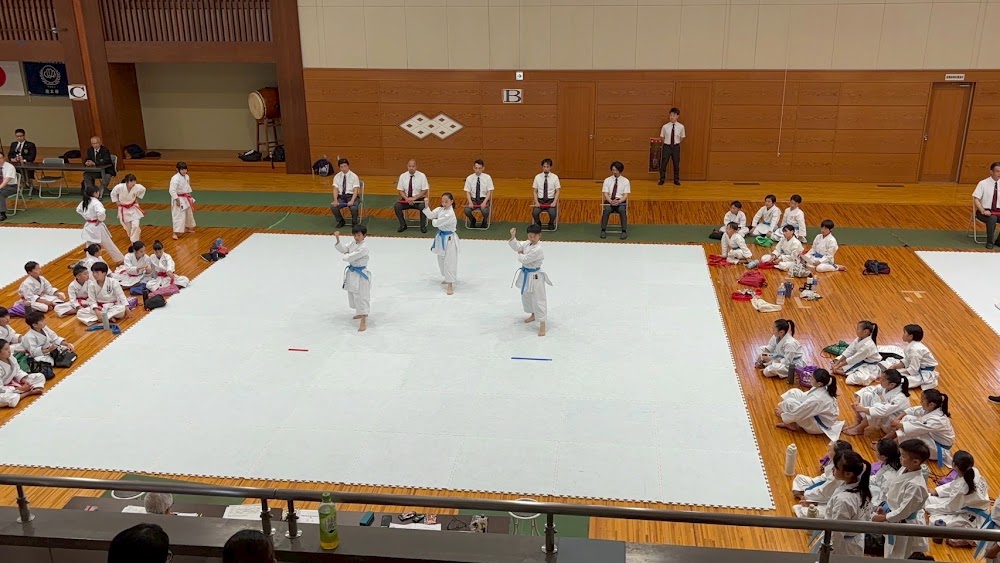 大会の舞台で形の演武をする選手クラスの子どもたち